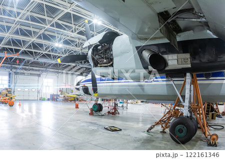 Transport turboprop airplane in the hangar. Aircraft under maintenance. Checking mechanical systems for flight operations 122161346