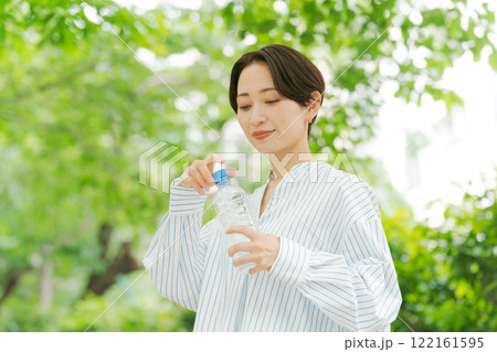 公園で水分補給する女性 122161595