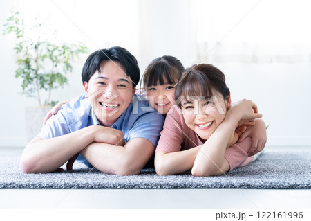 リビングで寝そべる3人家族 122161996