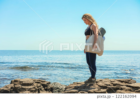 Active fitness yoga woman standing on cliff beach contemplate sea sky sunny landscape Active fitness yoga woman standing on cliff beach contemplate sea sky sunny landscape 122162094