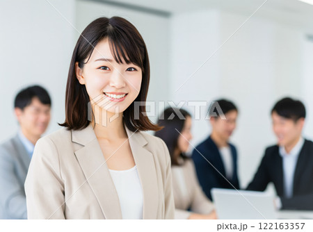 同僚が背景に見える女性社員のポートレート 122163357
