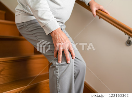 階段を降りるときに膝が痛む高齢者の男性 122163362