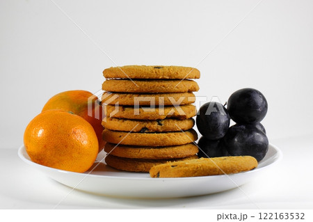 crispy cookies and fruits on a plate on a white background 122163532