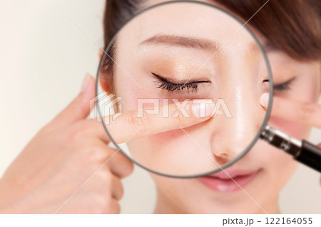若い女性のまぶたをルーペで拡大している。 若い女性のまぶたをルーペで拡大している。 122164055