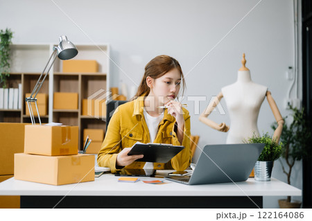 Startup small business SME, Entrepreneur owner woman using smartphone or tablet taking receive and checking online purchase shopping order 122164086