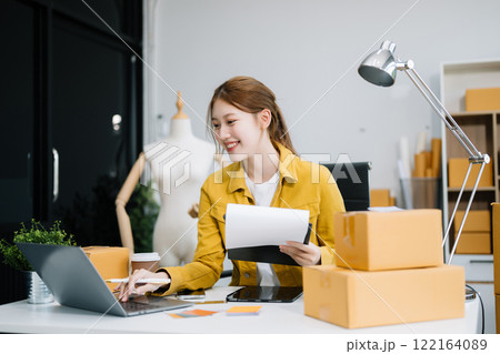 Young business owner woman prepare parcel box and standing check online orders for deliver to customer on tablet, laptop Young business owner woman prepare parcel box and standing check online orders for deliver to customer on tablet, laptop 122164089