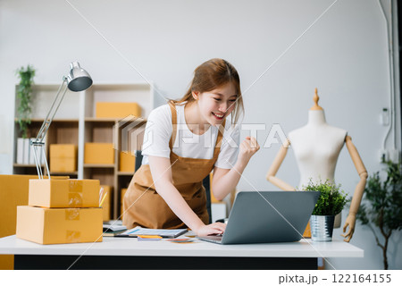 Young business owner woman prepare parcel box and standing check online orders for deliver to customer on tablet, laptop Young business owner woman prepare parcel box and standing check online orders for deliver to customer on tablet, laptop 122164155