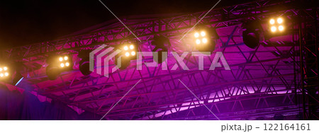 Close-up view of professional stage lighting mounted on metal truss. Bright spotlights at concert stage. Live music event Close-up view of professional stage lighting mounted on metal truss. Bright spotlights at concert stage. Live music event 122164161