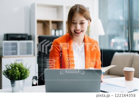 Asian businesswoman working with working notepad, tablet and laptop documents in the office E-document management Paperless workplace, e-signing, electronic signature, document management. Asian 122164358