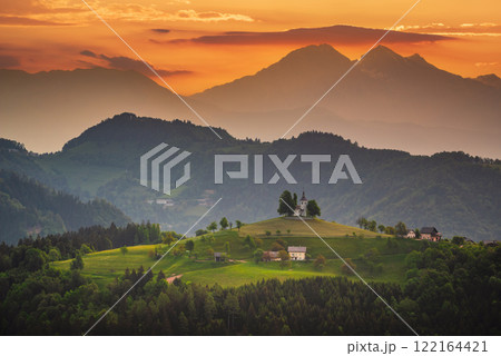 Sveti Tomaz, Slovenia. Amzing colored sunrise ski over Kamnik Savinja Alps and famous hilltop church. 122164421