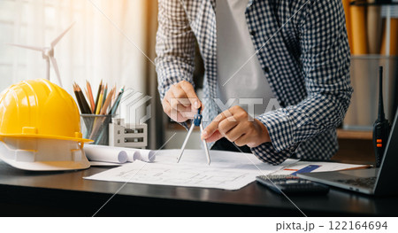 Creative architect projecting on the big drawings with architectural project at construction site at desk in office Creative architect projecting on the big drawings with architectural project at construction site at desk in office 122164694