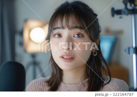 部屋で配信コンテンツの撮影をする日本人女性（ライブ配信・YouTube・クリエイター）	 122164787