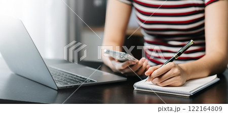 businesswoman hand working with new modern computer and writing on the notepad strategy diagram as concept 122164809