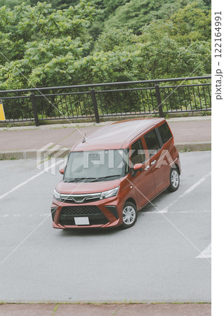 駐車場に停めた車に乗り込む女性 122164991