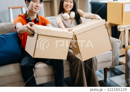 attractive couple man and woman with big boxes moving into a new house, new apartment for couple the new home, Moving house. 122165129
