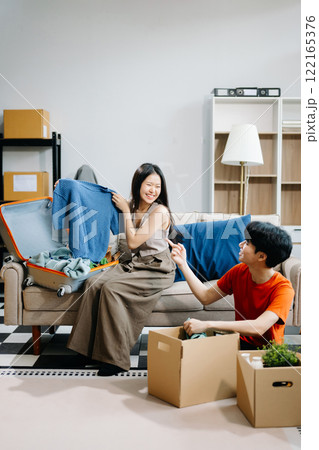 Asian young attractive couple man and woman use tablet and smartphone online shopping furniture decorate house with carton package move Asian young attractive couple man and woman use tablet and smartphone online shopping furniture decorate house with carton package move 122165376