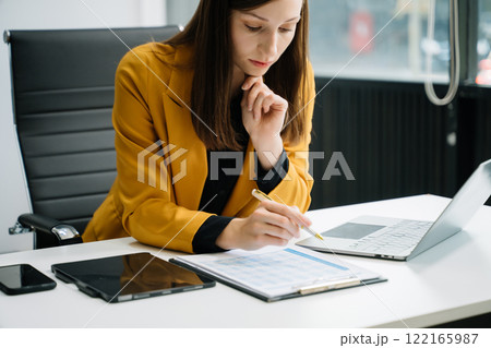 Business woman using tablet and laptop for doing math finance on an office desk, tax 122165987