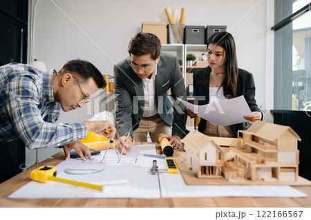 Engineer teams meeting working together wear worker helmets hardhat with on architectural project site and making model house. 122166567