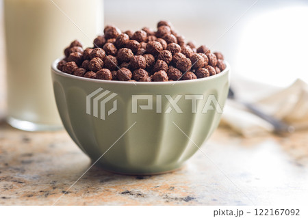 Breakfast cereal chocolate balls in bowl on kitchen table. 122167092