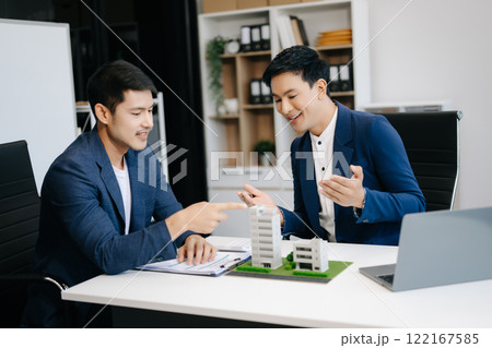 balancing the property sector The real estate agent is explaining the house style to see the house design and the purchase agreement. model house balancing the property sector The real estate agent is explaining the house style to see the house design and the purchase agreement. model house 122167585