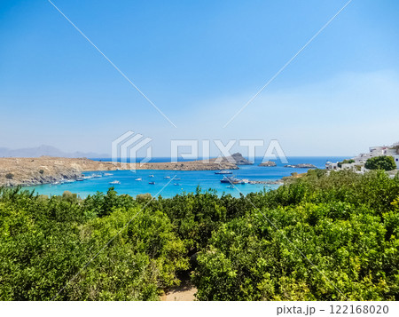 view of bay on Greek island, with crystal-clear waters, green foliage, and a few boats dotting the horizon. High quality photo view of bay on Greek island, with crystal-clear waters, green foliage, and a few boats dotting the horizon. High quality photo 122168020