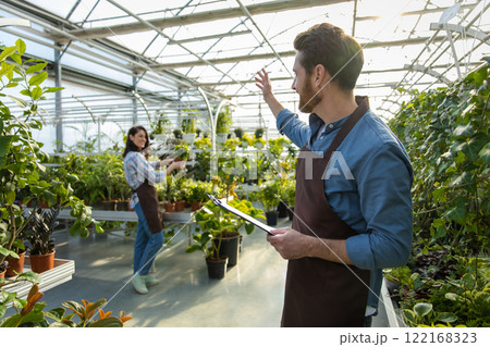 Male supervisor working in a greenhouse and looking positive 122168323