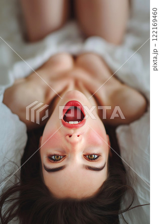 Erotic, sex, masturbation, cunnilingus, porn. Young woman having orgasm. Beautiful woman with open mouth enjoying sex lying in bed, couple making love. Sexual experience, sensual pleasure. 122169460