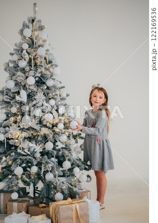 Cute little girl decorating christmas tree. Cute little girl decorating christmas tree. 122169536