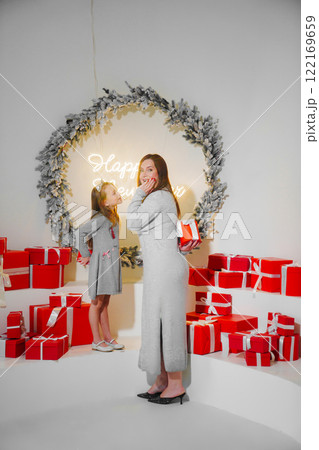 mom and daughter with red gift box in christmas decor. 122169659