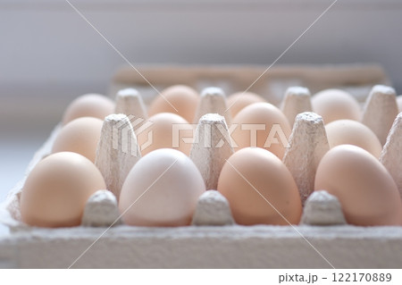 Fresh brown eggs in carton box rotating. Chicken eggs in packaging. Vertical footage for stories. Organic food. Close-up of hen eggs. Farm concept. Close-up in 4K, UHD 122170889