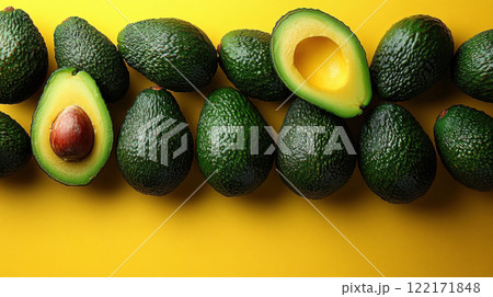 Whole avocados yellow background, top view avocado leaves, space for text, vegetarian food, vitamin 122171848