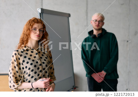 A business colleague collaboratively presenting business goals and strategies to their team in a professional office setting A business colleague collaboratively presenting business goals and strategies to their team in a professional office setting 122172013