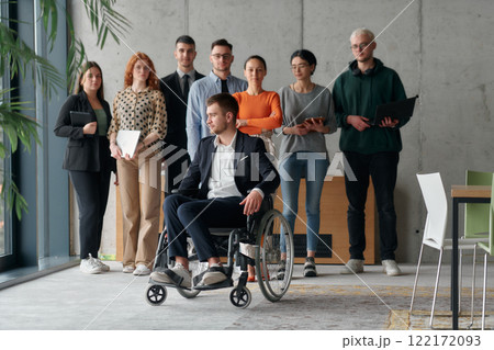Multiethnic Business Team Collaborating in a Modern Office with Director in a Wheelchair Multiethnic Business Team Collaborating in a Modern Office with Director in a Wheelchair 122172093