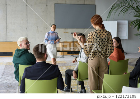 A diverse group of business professionals sits attentively in a modern office, actively participating in a training session led by an instructor, focusing on the latest technological advancements in A diverse group of business professionals sits attentively in a modern office, actively participating in a training session led by an instructor, focusing on the latest technological advancements in 122172109