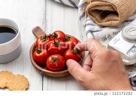 美味しそうなミニトマトを食べる 美味しそうなミニトマトを食べる 122172282