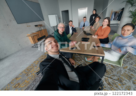 A group of business professionals taking a selfie during a break in an office meeting, capturing a moment of teamwork and collaboration in a modern workplace A group of business professionals taking a selfie during a break in an office meeting, capturing a moment of teamwork and collaboration in a modern workplace 122172343