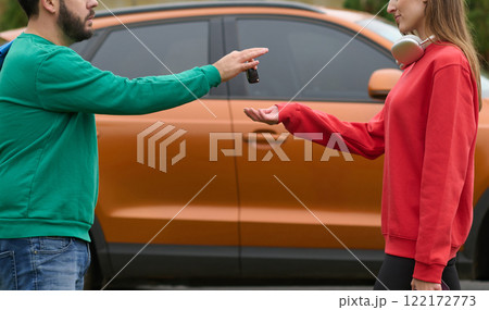Car keys handshake, seller or car salesman and customer in a dealership, shake hands over the car keys Car keys handshake, seller or car salesman and customer in a dealership, shake hands over the car keys 122172773