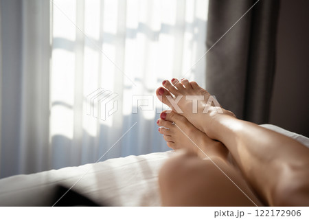 Close-up of a young woman's legs on the bed. 122172906