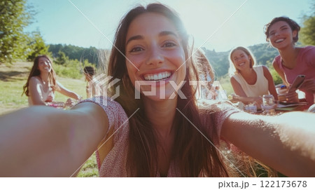 A happy woman taking a selfie with friends during a picnic in nature.. Generated image 122173678