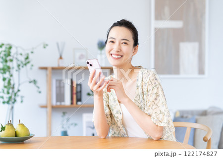 家でスマホを使う若い女性 122174827
