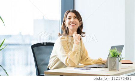デスクワークをする笑顔の女性・ビジネスウーマン デスクワークをする笑顔の女性・ビジネスウーマン 122175483