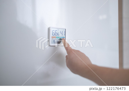 hand adjusting air conditioner button at 70 degree Fahrenheit in the apartment for comfortable hand adjusting air conditioner button at 70 degree Fahrenheit in the apartment for comfortable 122176473