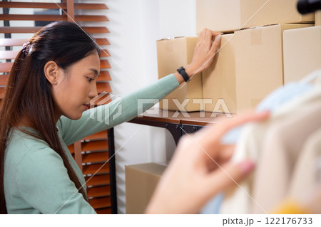 Young asian woman check stock packaging or boxes product in home office. 122176733