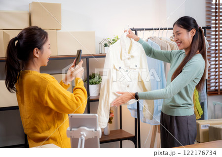 Two asian woman taking picture of clothes for online store. 122176734