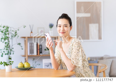 自宅でスマホを使う若い女性 122177747