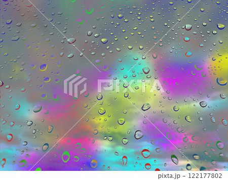 Colourful rainy window glass with macro raindrops. Abstract rainy drops on a window surface. Wet glass. Water droplets. An iridescent rainbow sky. 122177802