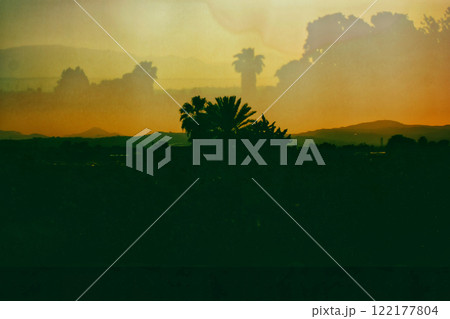 Tropical landscape Mountains, hills on horizon in sunset. Double exposure. Spanish landscapes, wild nature. Palm trees silhouettes. Film filter photo. 122177804