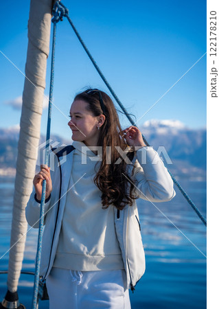 Portrait of young woman on bow of the yacht during sailing in the morning in winter time in Adriatic sea, yacht life and yachting concept 122178210