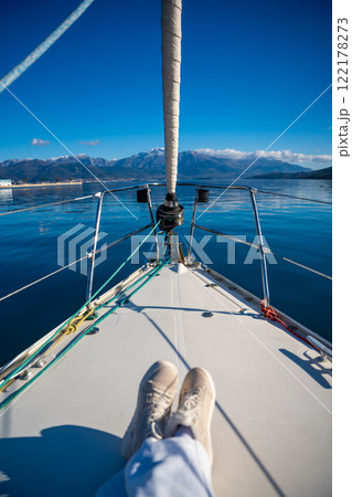 Feet of young woman on bow of the yacht during sailing in the morning in winter time in Adriatic sea, yacht life and yachting concept 122178273