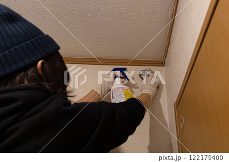 室内清掃をしている女性の後姿　内装の汚れを洗剤で掃除している 122179400
